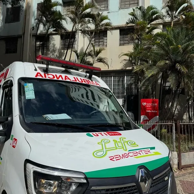 Equipe da Life Remocenter uniformizada ao lado de ambulância UTI móvel durante atendimento noturno